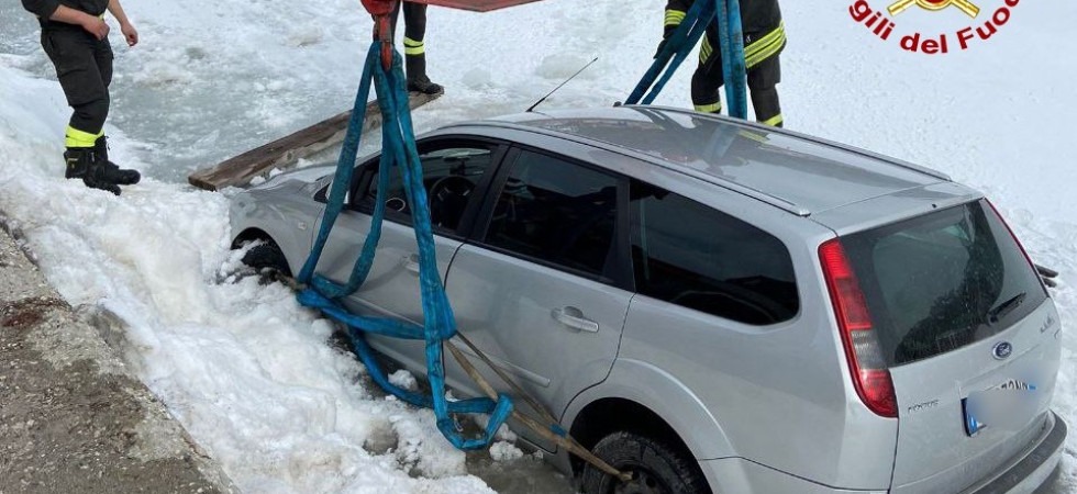 Esce di strada e finisce nel lago ghiacciato: pompieri al lavoro con l'autogru per recuperare l'auto